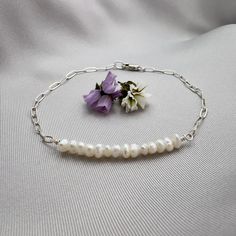 ✦This easy to wear bracelet is made with beautiful tiny and irregular tiny white pearls, measuring 3 to 4mm in size. Half of the bracelet is made of pearl and the other half is made of a a delicate sterling silver paperclip chain with links that measure 4mm x 2mm.  ✦The bracelet closes with a sterling silver elongated lobster clasp that can be placed at any position along the chain to make for an adjustable size if desired.  ✦The bracelet length is available in lengths from 6.5 inches to 9 inches. Please select bracelet length at check out. See below for information on how to determine the best size for your write.  ✦For custom length, please contact seller. HOW TO MEASURE ✦The best way to measure for a bracelet is to take a piece of string (or dental floss, whatever) and wrap it around yo Minimalist Pearl Bracelet With Adjustable Chain, Minimalist Silver Pearl Bracelet With Adjustable Chain, Minimalist Sterling Silver Pearl Bracelet, Delicate Sterling Silver Pearl Bracelet With Charm, Minimalist Sterling Silver Pearl Bracelet With Charm, Minimalist Sterling Silver Pearl Chain Bracelet, Everyday White Pearl Bracelet With Adjustable Chain, Dainty Sterling Silver Pearl Bracelet With Charm, Dainty Sterling Silver Pearl Drop Bracelet