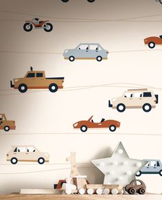 a wall with cars on it and a star in the middle, next to a shelf