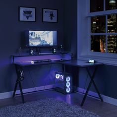 a desk with a computer on it in front of a window and a city view