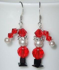 a pair of red and white beaded earrings with pearls, crystals and swaroons