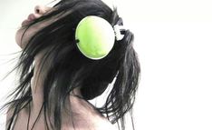 a woman with black hair has an apple on her head