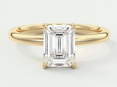 an emerald cut engagement ring with a thin band on the side and a diamond in the center