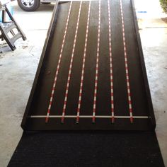 a track with red and white lines on it in a garage next to a truck