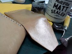 the leather is being worked on with paint and other crafting supplies to make it