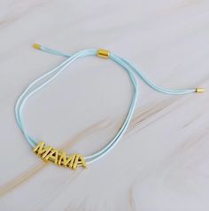 This beautiful MAMA bracelet is made of a slim satin thread with simple golden font. Its clean, minimalist design features adjustable drawstring size for easy fitting, with each letter that moves independently around the thread. Perfect for the fashionable, yet understated, mother. Dimensions: approximate 10" Perimeter Fully Adjustable With a Slide 18K Gold Plated Brass Lead and Nickel Free Images and Description Courtesy of Ellison & Young Adjustable Custom Name Friendship Bracelets For Everyday, Custom Name Adjustable Friendship Bracelet For Everyday, Adjustable Name Bracelet For Friendship, Adjustable Gold Friendship Bracelets With Letter Beads, Adjustable Gold Bracelet With Nylon Cord, Gold Resizable Friendship Bracelets With Nylon Cord, Adjustable Gold Nylon Cord Bracelet, Gold Nylon Cord Bracelet For Everyday, Gold Friendship Bracelets With Adjustable Nylon Cord