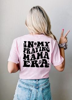 Trendy Praying Mama Shirt Welcome to our shop!  Our Bella Canvas 3001 shirt fits true to size. Please note some models are wearing an oversized version, In order to achieve that desired look please go up 1 or 2 sizes. This shirt has a unisex fit, nice fit on women, but men should SIZE UP at least one size.  Other details   .: 100% Airlume combed and ringspun cotton (fiber content may vary for different colors) .: Light fabric (4.2 oz/yd² (142 g/m .: Retail fit .: Tear away label .: Runs true to Relaxed Fit Pink Top With Lettering, Pink Cotton Tops With Lettering, Mother's Day Slogan Top With Relaxed Fit, Short Sleeve Tops With Lettering For Mother's Day, Mother's Day Cotton Tops With Lettering, Relaxed Fit Tops With Lettering For Mother's Day, Pink Shirt For Mother's Day, Pink Tops With Text Print For Mother's Day, Pink Relaxed Fit Tops For Mother's Day