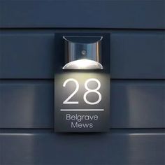 an illuminated sign on the side of a building reads 28 belgrave mews