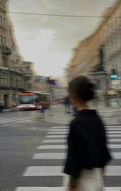 a blurry photo of a woman crossing the street