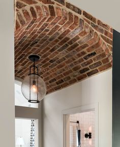 a brick ceiling with two lights hanging from it's side and another light on the other side