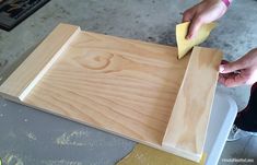 someone is sanding wood with a sponge and a cloth on top of the board