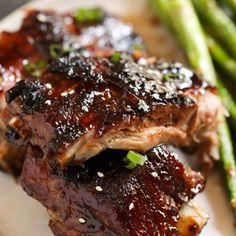 some meat and asparagus on a white plate