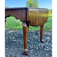 an old wooden table sitting on top of gravel