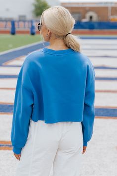 This Florida Blue Cropped Sweatshirt makes for a cute game day look! Made from 100% polyester, this long-sleeved sweatshirt features raw edges and fuzzy text detailing for added comfort and style. Whether you're tailgating or lounging at home, this cropped sweatshirt will keep you cozy and fashionable for each and every game! Simply style it with your favorite white denim and sneakers to complete the look. Spring Varsity Long Sleeve Tops, Trendy Long Sleeve Sweatshirt For Sports Season, Blue Oversized French Terry Sweatshirt, Oversized Blue French Terry Sweatshirt, Blue Sweatshirt For Fall Loungewear, Team-colored Fall Sweatshirt With Ribbed Cuffs, Blue Varsity Tops For Game Day, Collegiate Long Sleeve Sweatshirt For Game Day, Team-colored Sweatshirt With Ribbed Cuffs For Fall