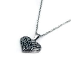 Elevate your outfit with Cobweb Heart Necklace – our exclusive stainless steel necklace designed with intricately crafted spiderweb detailing. This gothic-inspired necklace offers a subtle and refined way to add a spooky touch to your jewellery collection. Gothic Metal Necklace With Heart Pendant, Gothic Heart Pendant Metal Necklace, Gothic Metal Heart Pendant Necklace, Gothic Metal Heart Necklace, Gothic Heart Pendant Jewelry, Gothic Heart Pendant Necklace, Heart-shaped Metal Jewelry For Halloween, Gothic Stainless Steel Pendant Necklace, Halloween Heart-shaped Metal Jewelry