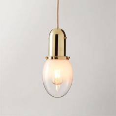 Inspired by French industrial fixtures, the Lille glass pendant by goop offers a surprising mix of materials. Suspended from a rose gold cloth cord, a drop of ombre glass encases the bulb, topped with an unlacquered brass cap. The gentle transition to clear glass softens the design with a feminine edge-a Gwyneth Paltrow design signature. Polished unlacquered brass hardware offers a living finish that will develop the patina of a vintage find. CB2 exclusive.Due to the nature of the material, bras Industrial Fixtures, Unlacquered Brass Hardware, Silver Lamp, French Industrial, Gold Pendant Lighting, Brass Patina, Gold Table Lamp, Pendant Lights & Chandeliers, Taper Candle Holders