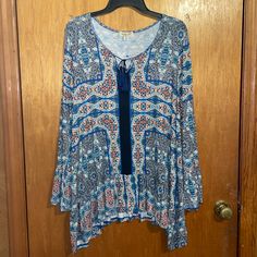 One Worldnwot Blue Colorful Boho Tassel Front Tie Keyhole Shark Bite Hem Bell Sleeve Slouse Size 1x. Excellent New Condition. Tags Were Removed But Never Worn Or Washed. Beautiful Colorway Of Blue/Navy And Colorful Bohemian Print. Has Peplum Ruffle Shark Bite Waistline Hem, Tassel Front Tie Keyhole, And Beautiful Bell Sleeve. This Blouse Has All The Details And Colors. Materials: 96% Viscose 4% Spandex Measurements: (Approximately) Pit To Pit- 23" Length- 35" Blue Beach Tops With Tassels, Beach Blue Tops With Tassels, Blue Spring Top With Tassel Ties, Blue Spring Tops With Tassel Ties, Blue Tassel Tops For Beach, Bohemian Blue Top With Tassels, Casual Blue Tops With Tassel Ties, Blue Beach Tops With Tassel Ties, Blue Bohemian Top With Tassel Ties