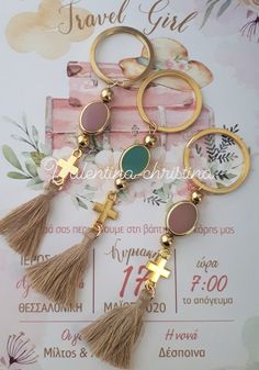 three key chains with tassels and cross charms on top of eachother