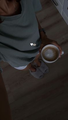 a woman holding a cup of coffee in her hands