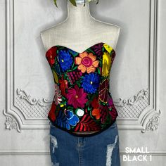 a women's corset with colorful flowers on the front and back, hanging from a mannequin