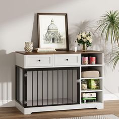 a white and black cabinet with drawers in the corner next to a potted plant