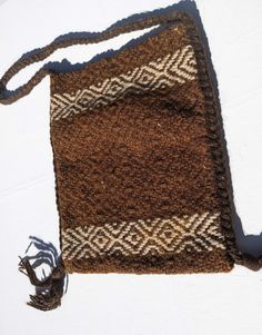 Lovely vintage brown and light beige woven, chunky wool, hippy style bag, circa 1970's-80's.  With plaited dark brown woollen strap and knotted tassels on each side, it has an attractive diamond motif design and is quite strong and sturdy. The plaited strap runs down each side to finish with the knotted tassel.  There is no fastener but a prestud could be affixed, if desired,  inside or a a button/toggle on the outside with a loop  sewn on the other side and looping over the top.  The strap is f Brown Crochet Bag With Tassels For Everyday Use, Everyday Brown Crochet Bag With Tassels, Artisan Brown Fringe Bag, Brown Artisan Bags With Fringe, Artisan Brown Bag With Fringe, Artisan Brown Bags With Fringe, Bohemian Brown Crochet Bag With Adjustable Strap, Brown Handwoven Shoulder Bag For Festivals, Bohemian Brown Woven Shoulder Bag