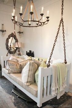 a living room filled with lots of furniture and a chandelier hanging from the ceiling