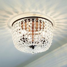 a chandelier hanging from the ceiling in a room with white walls and ceilings