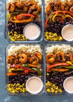 four plastic containers filled with rice, black beans, and shrimp next to dipping sauces