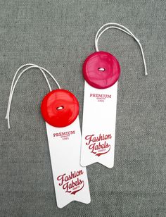 two red and white tags with the words fashion labels printed on them are sitting next to each other