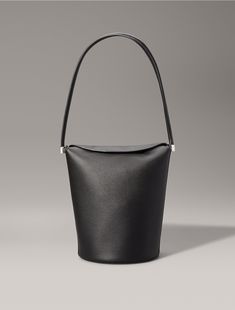 Crafted from 100% faux leather, this shoulder bag features solid, minimal styling. Designed with a top flap closure and detailed with an embossed CK monogram logo at the side. A simple silhouette, this bag is perfect for holding essentials on your evening out.  Material: 100% Polyurethane. Ck Monogram, Simple Silhouette, Monogram Logo, Bucket Bag, Calvin Klein, Faux Leather, Women Accessories, Monogram, Shoulder Bag