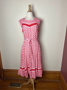 Vintage 70s unbranded picnic core gingham sundress. Straight from Paris! Adorable 70s gingham sundress with sweet lace detailing along bust line and and bottom ruffle. Three different red and white fabrics, mini gingham, large scale gingham and red and white polka dots. Sleeveless, ruffled bottom, zip closure in back. Lovely seaming creates flattering lines for the figure! Sash tie around waist. Hits mid-calf to ankle depending on your height! 100% cotton, no size listed, but would best fit a mo Picnic Gingham Sundress With Ruffles, Polka Dot Summer Dress For Picnic, Spring Gingham Sundress With Ruffles, Polka Dot Dresses For Summer Picnic, Retro Plaid Summer Dress, Spring Retro Gingham Dress, Retro Cotton Dress For Picnic, Retro Gingham Dress For Picnic, Vintage Ruffled Sundress For Spring