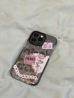 a cell phone case with an image of a cat on it sitting on a bed