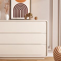 a white dresser sitting in a living room next to a painting