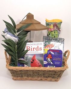 a bird sitting on top of a basket filled with books and other items next to a umbrella