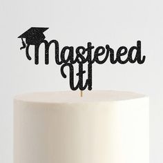 a cake topper that says,'mastered it'with a graduation cap on top