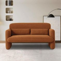 an orange couch sitting on top of a white floor next to a book shelf filled with books