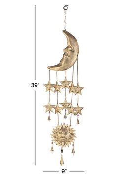 a gold moon and stars wind chime hanging from the side of a white wall