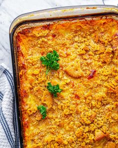 a casserole dish with meat and vegetables in it on a white table cloth