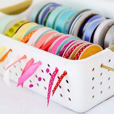 a white container filled with lots of different colored ribbons