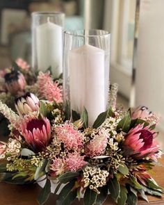 flowers and candles on a table in front of a mirror