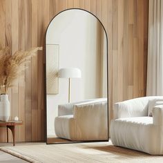 a mirror sitting on top of a wooden floor next to a white chair and table