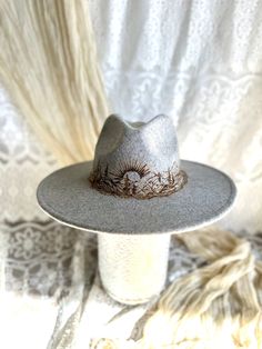 The mountain scape on this gray wool hat are hand burned to create a stylish piece that would be perfect as a lovely boho statement piece.  The hat is size Large. Mountain Burned Hat, Felt Burned Hats, Burning Mountain, Burned Hats, Mountain Scape, Hat Burning, Custom Cowboy Hats, Custom Made Hats, Hand Burn