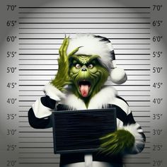 the grinch is holding a sign in front of his muggy mugshots