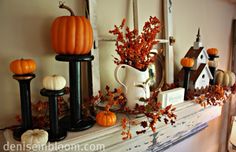 a mantle filled with pumpkins and other decorations