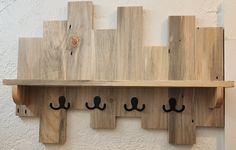 a wooden shelf with four hooks on it