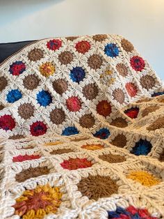 a crocheted granny blanket is sitting on a couch