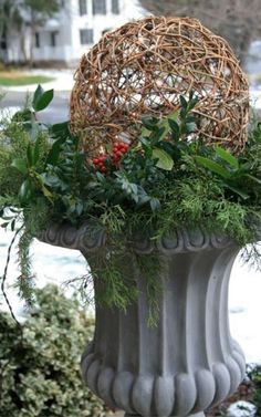 a planter filled with greenery sitting on top of a sidewalk