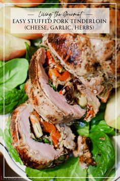 a white plate topped with meat and veggies on top of a green leafy salad