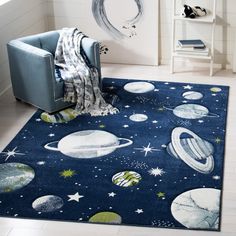 a blue rug with planets and stars on it in a white living room, next to a chair