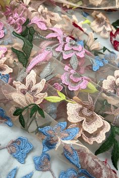 the fabric has many different colored flowers on it, including pinks and purples